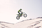 Bike, sand and jump with a sports man riding a vehicle in the desert for adventure or adrenaline. Motorcycle, training and ramp with an athlete outdoor in nature for freedom, power or competition