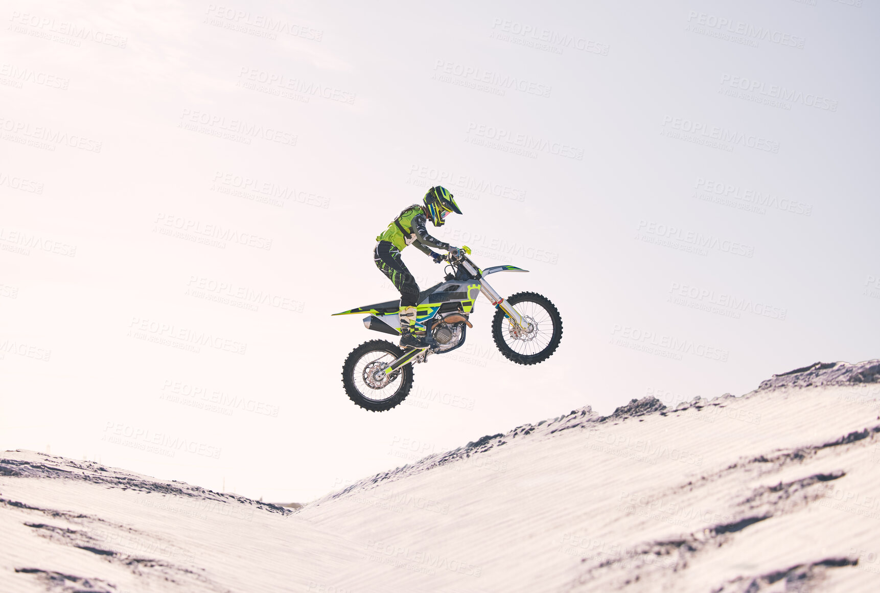 Buy stock photo Bike, sand and jump with a sports man riding a vehicle in the desert for adventure or adrenaline. Motorcycle, training and ramp with an athlete outdoor in nature for freedom, power or competition