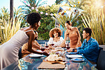 Friends, outdoor and eating food at a table for social gathering, happiness and holiday celebration. Diversity, men and women group at lunch, party or reunion with wine in a garden for fun and relax