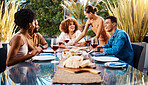 Friends, people and food outdoor on a table for social gathering, happiness and holiday celebration. Diversity, men and women group eating lunch at a party or reunion with drinks to relax in a garden