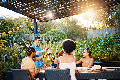 Buy stock photo Cheers, friends at dinner in garden at party and celebration with diversity, food and wine at outdoor party. Glass toast, men and women at table, fun people with sunset drinks in backyard together.