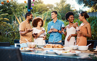 Talk, friends at dinner in garden at party and celebration with diversity, food and wine at outdoor event. Conversation, men and women at table for lunch, fun people with drinks in backyard together.