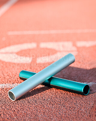 Sports, track and closeup of baton in a stadium for a relay race, marathon or competition. Fitness, running and zoom of athletic equipment on the ground for cardio training, workout or exercise.