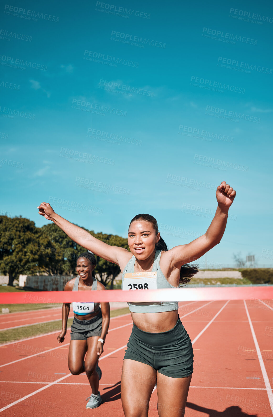 Buy stock photo Happy woman, running and winning by finish line in race, competition or marathon on outdoor stadium track. Female person or runner in celebration for victory, achievement or sports accomplishment