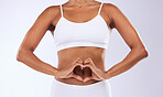 Heart, hands and stomach of woman for wellness, nutrition, fitness and diet in studio on white background. Closeup, person and nutritionist in underwear for gut health, colon and transformation