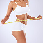 Body, woman and measurement to lose weight on a white background for fitness, health or wellness. Gym, training and a girl or model with a tape to check exercise progress or results on a backdrop