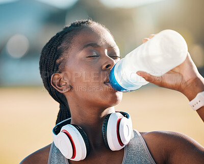 Buy stock photo Black woman, drinking water and health, fitness and runner outdoor with headphones, thirsty after workout with cardio. Bottle, hydration and h2o, exercise and wellness with athlete, music and sports