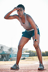 Sweating, tired and black woman at stadium for a race, training or breathing after cardio. Sports, workout and an athlete or African runner with a break after fitness, running or exercise on a track