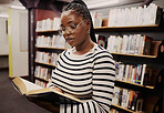 Black woman, library and books for school, student reading or education, English and language research. Young person focus by bookshelf for studying, literature catalog and free resources in glasses