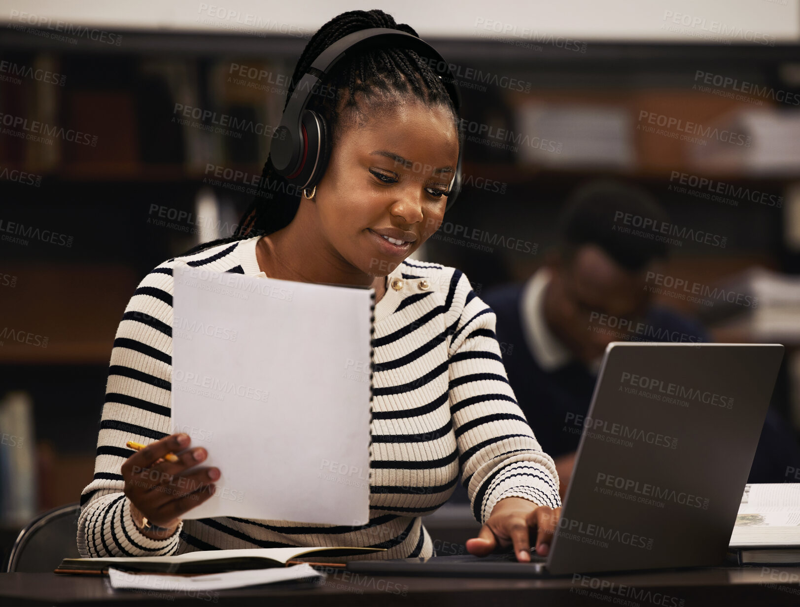 Buy stock photo Woman, studying and headphones in library for research, documents and computer research or planning in university. African student reading paper, listening to music or laptop for focus and e learning