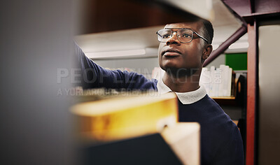 Buy stock photo Knowledge, research and black man in a library search and learning on campus for studying and education in college. Smart, clever and young person in an academy with books on a shelf for an exam