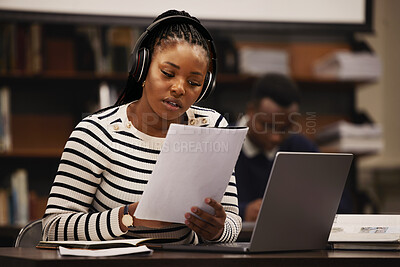 Buy stock photo Woman, documents and headphones in library for research, studying and computer research or planning in university. African student reading paper, listening to music and laptop for focus and learning