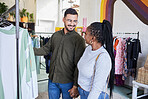 Interracial couple, shopping and retail, clothes and fashion with happiness and commerce. Customer, people in boutique or shop holding hands with discount, sale and browsing in store at mall