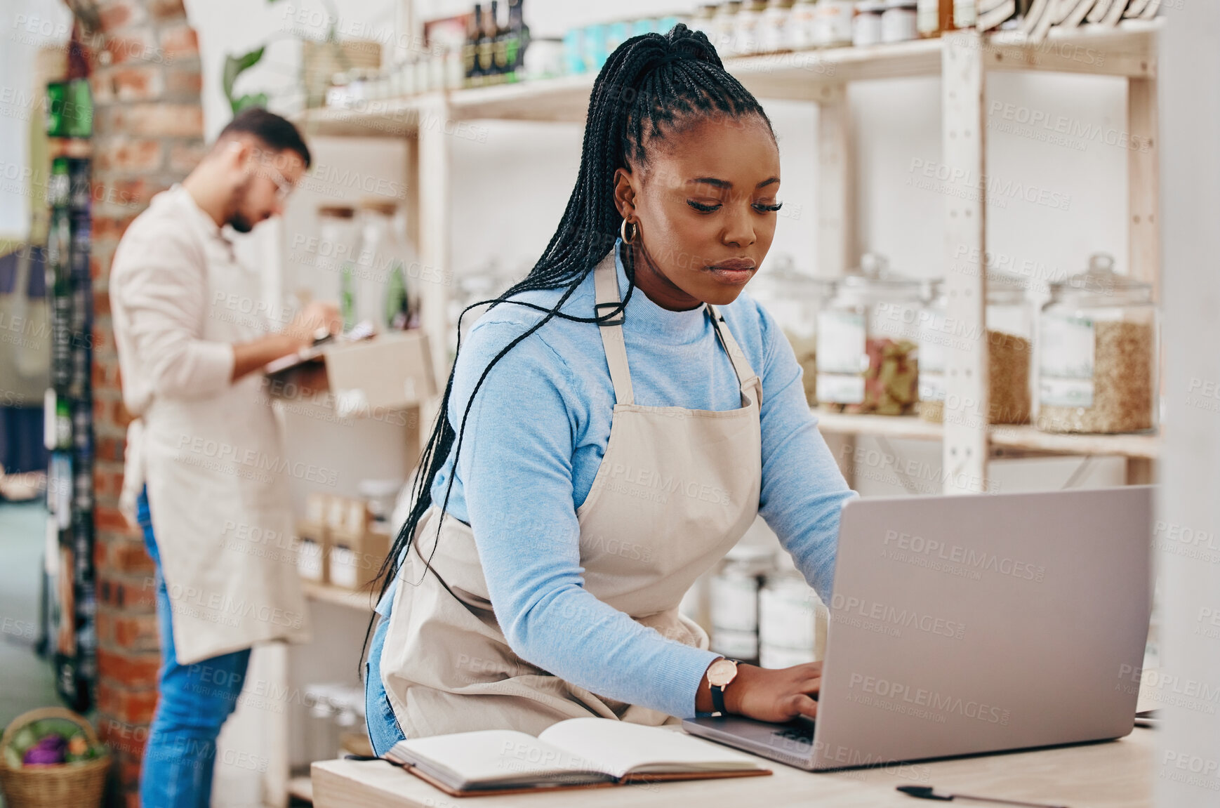 Buy stock photo Grocery store, small business and black woman at counter with laptop for stock inventory, planning and sales report. Computer, internet and manager at sustainable supermarket with eco friendly care.