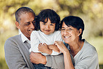 Family, portrait and hug by child and grandparents in a park with care, bond and fun on blurred background. Love, smile and face of senior people embrace retirement freedom with kid in a forest