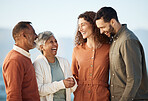 Happy family, parents and couple laughing at the beach for holiday or vacation together and bonding for happiness. Travel, man and woman with elderly people at the sea or ocean with freedom and relax