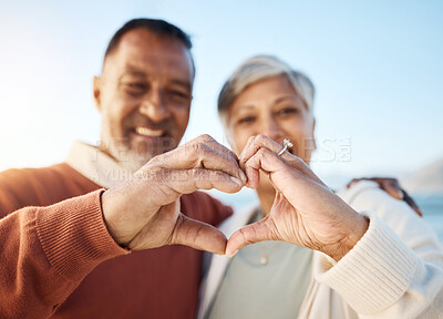 Buy stock photo Senior couple, heart hands and beach portrait for love, icon or smile in summer, sign language or symbol. Man, woman and happy marriage with emoji, outdoor or together for holiday by ocean in Jakarta