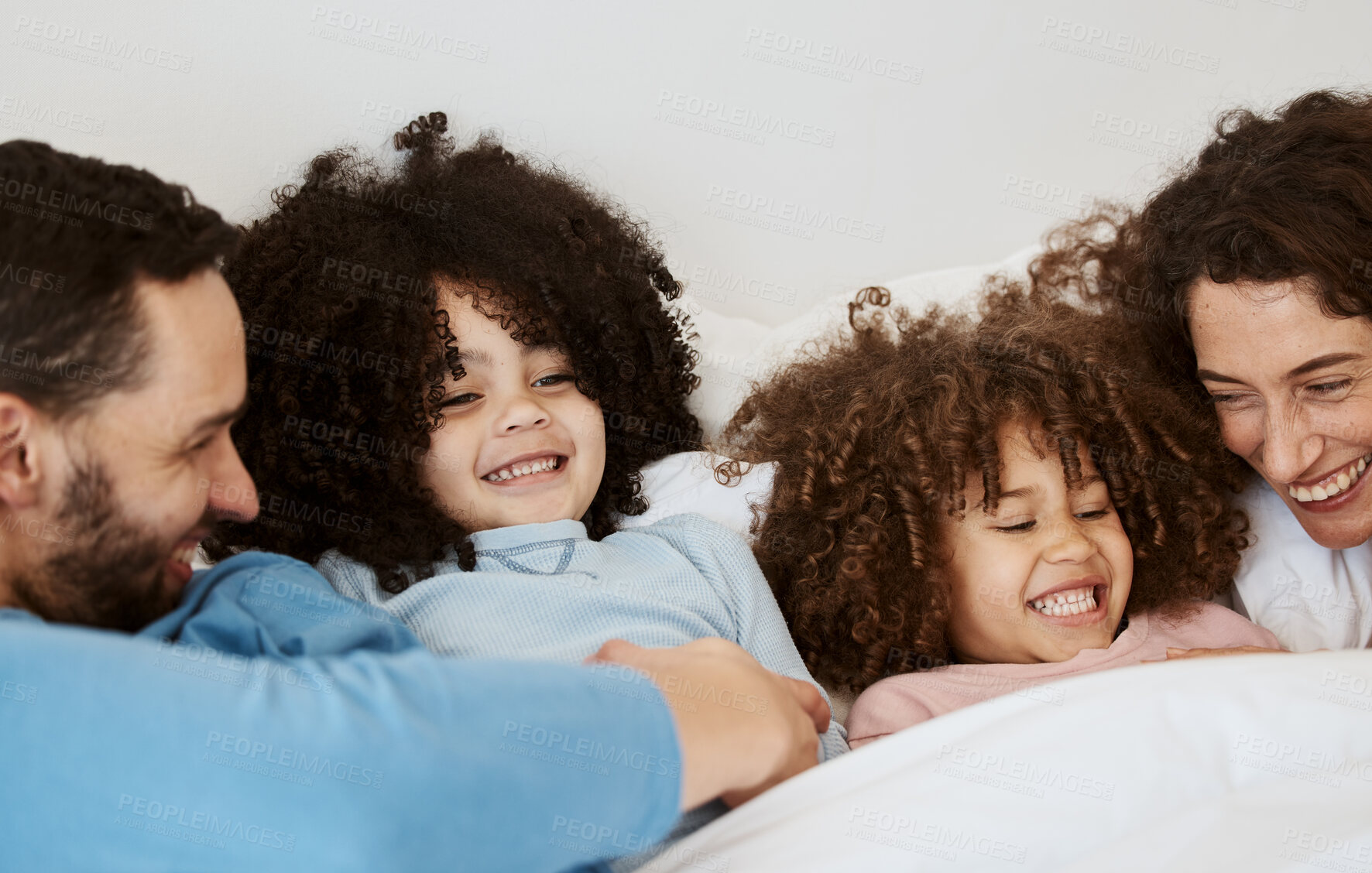 Buy stock photo Bedroom, children and parents laughing, relax and bond with interracial kids, playful and enjoy funny weekend. Home bed, comedy and happy family, mom and dad wellness, morning and care for youth 