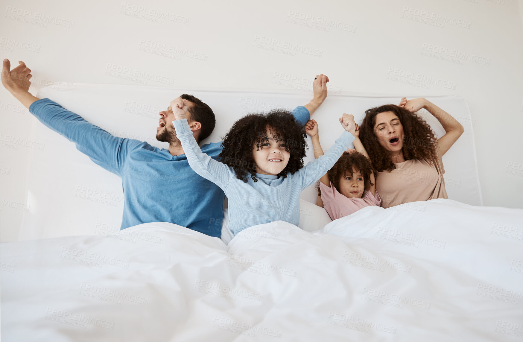 Buy stock photo Family, bed and yawn in morning wake up, relax or sleep together with arms up at home. Calm parents, children and bonding on holiday break, weekend or new day in peace, support or comfort in bedroom