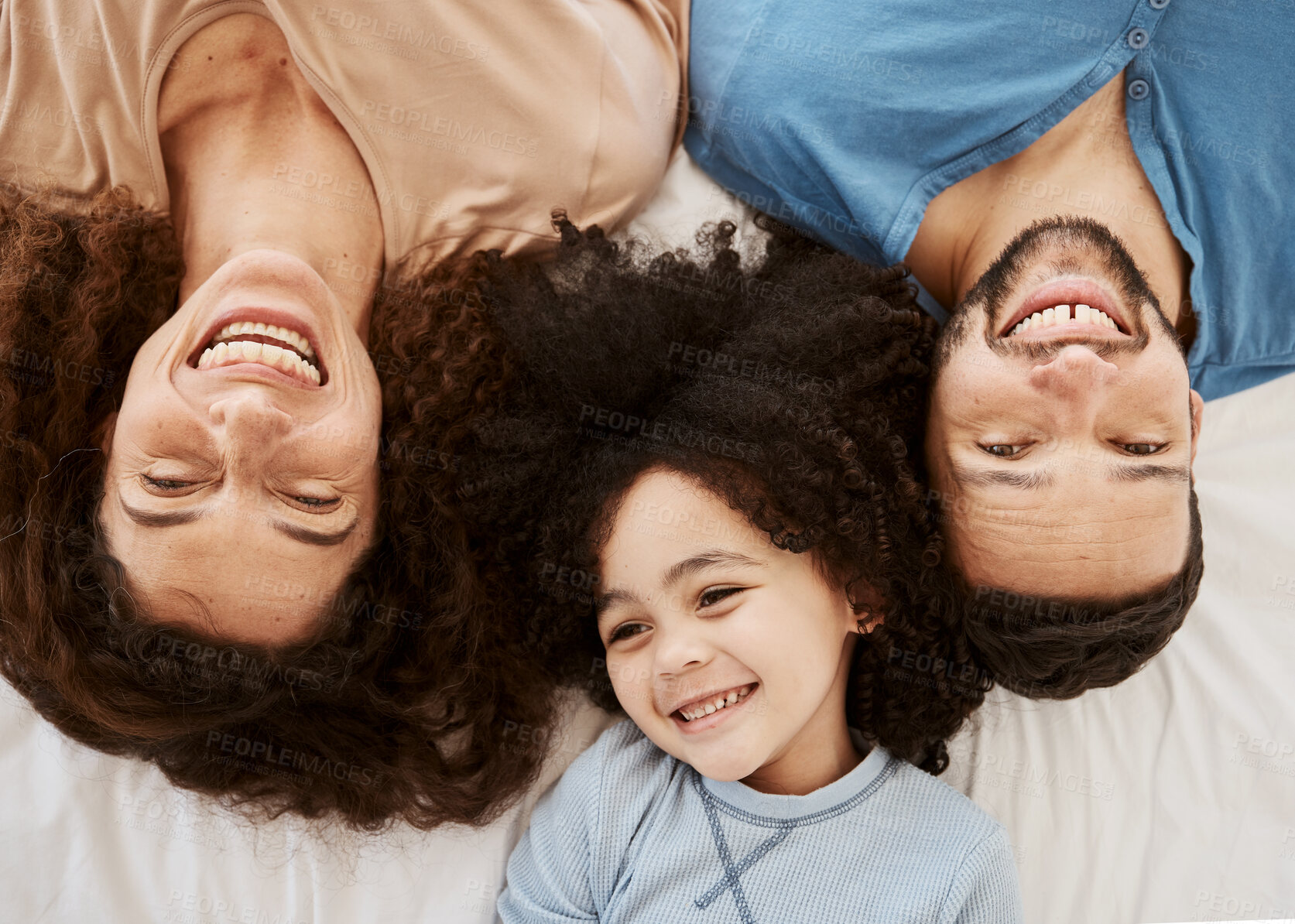 Buy stock photo Bedroom top view, child and parents laugh, connect and enjoy quality time together, rest or funny joke, humour or comedy. Home bed, morning closeup and face of happy family kid, mom and dad wellness