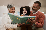 Grandparents, child and reading with book, sofa and thinking with support, learning and education. Senior man, woman and young kid with story, teaching and helping with development in family house