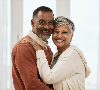 Buy stock photo Happy, portrait and senior couple in home living room, bonding together and hug. Face smile, man and Indian woman in lounge for care, love or support for connection in healthy relationship at house