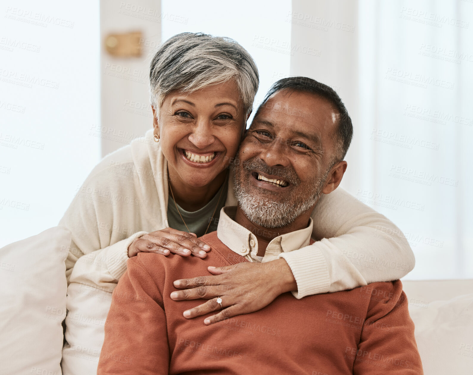 Buy stock photo Smile, portrait and senior couple hug on sofa in living room relax, laugh and bond in their home. Face, smile and old man embrace elderly woman in a lounge with love, satisfied and enjoy retirement