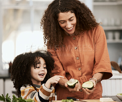 Buy stock photo Family, avocado and a mother cooking with her daughter in the kitchen of their home together for nutrition. Food, health or diet with a woman teaching her child about eating green vegetables