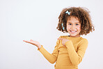 Portrait, smile and kid pointing to palm in studio isolated on a white background space. Face, hand mockup and happy girl child advertising, show marketing and presentation of commercial promotion