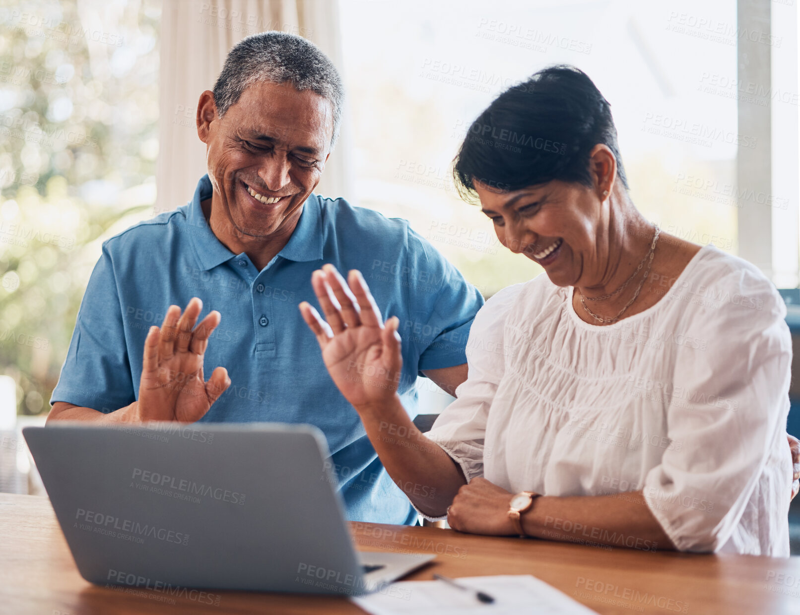 Buy stock photo Video call, wave and senior couple with laptop in a dining room together for communication. Happy, smile and elderly man and woman in retirement greeting for virtual conversation on computer at home.