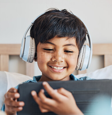 Buy stock photo Face of kid, headphones and tablet in home for reading ebook, watch movies and play video game on elearning app. Happy boy child, digital tech and listening to multimedia, music and streaming cartoon