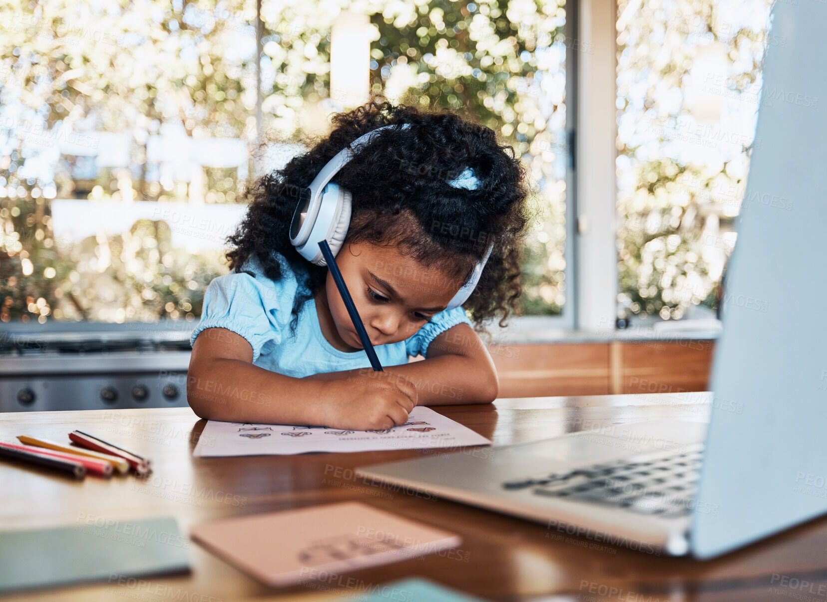 Buy stock photo Online learning, headphones and child writing assessment at desk for creative education and development. Audio tech, study and kid with laptop for elearning, virtual help and reading growth at home