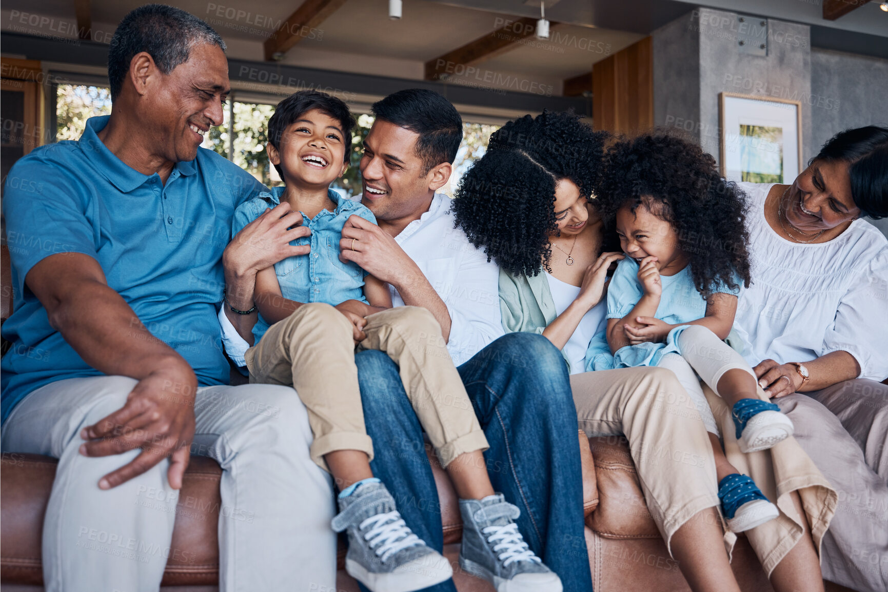 Buy stock photo Laughing, big family and on a home sofa for conversation, visit or bonding. Happy, together and parents, children and grandparents on a couch for a joke, comedy or communication in the living room