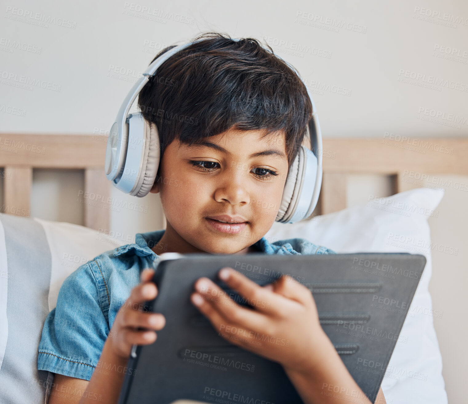 Buy stock photo Face of boy, headphones and tablet in home for reading ebook, watch cartoon and play video games on elearning app. Child, kid and listening to multimedia, music and streaming movies on digital tech 