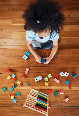 Above, child and toys for learning on the floor, home education and fun activity. House, young and a girl kid with blocks and abacus for recreation, math or perspective on the ground in childhood
