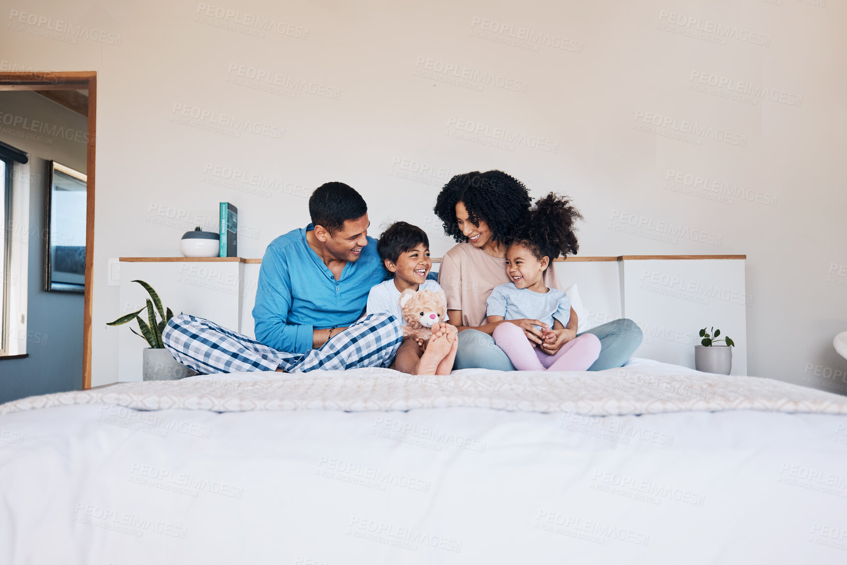 Buy stock photo Happy, smile and family on bed talking, bonding and relaxing together with love at their home. Happiness, excited and young children speaking to their parents from Colombia in the room of their house