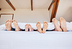 Family, morning and feet in bed to relax together closeup in their home on the weekend with mockup. Mother, father and kids in the bedroom on mattress while on holiday or vacation in their apartment