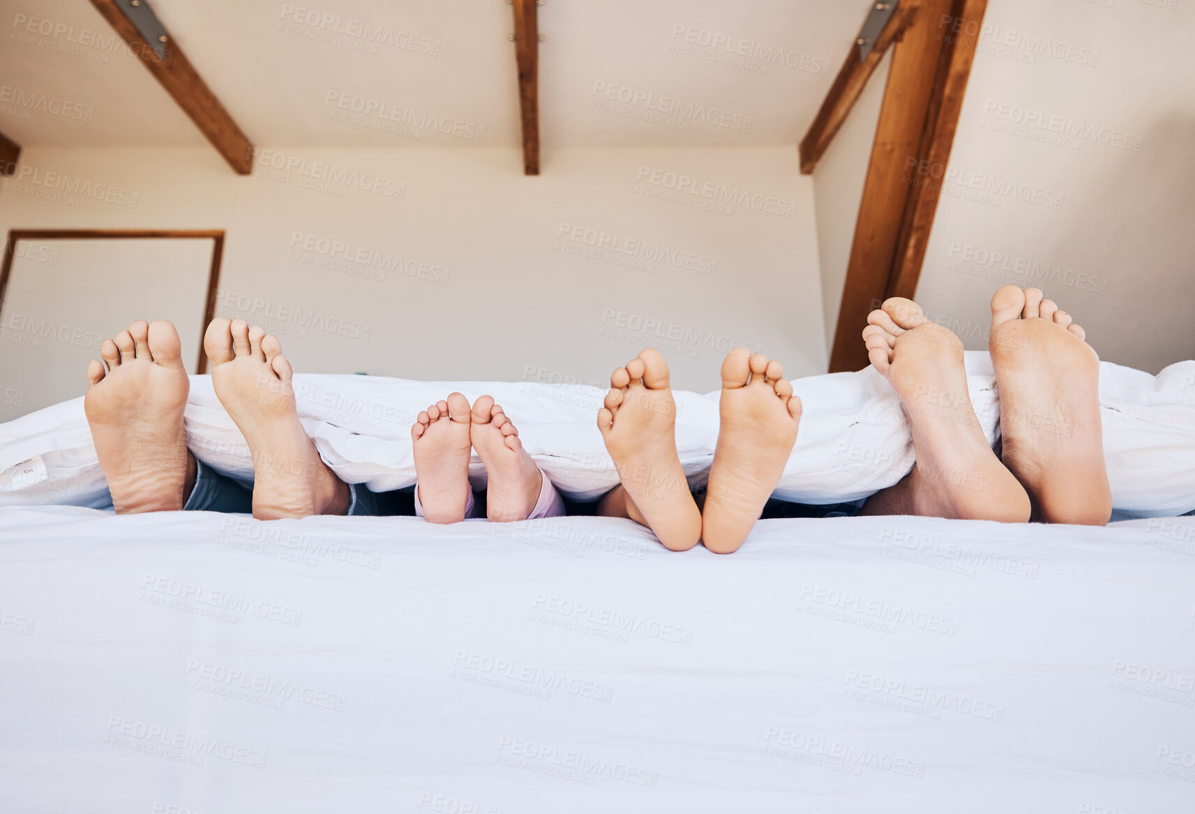 Buy stock photo Family, morning and feet in bed to relax together closeup in their home on the weekend with mockup. Mother, father and kids in the bedroom on mattress while on holiday or vacation in their apartment