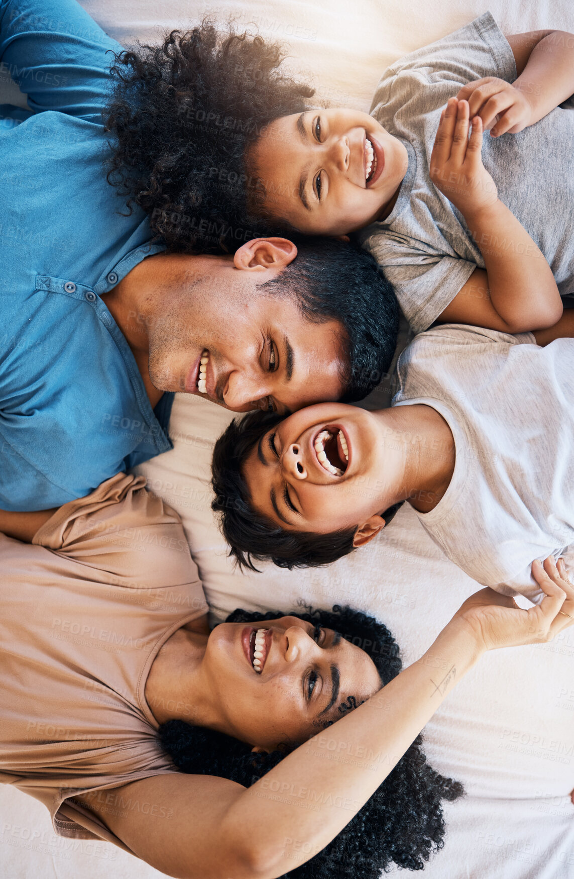 Buy stock photo Above, laughing and portrait of a family on the bed for bonding, love and comic conversation. Together, house and parents with children for talking, jokes or funny communication in the bedroom