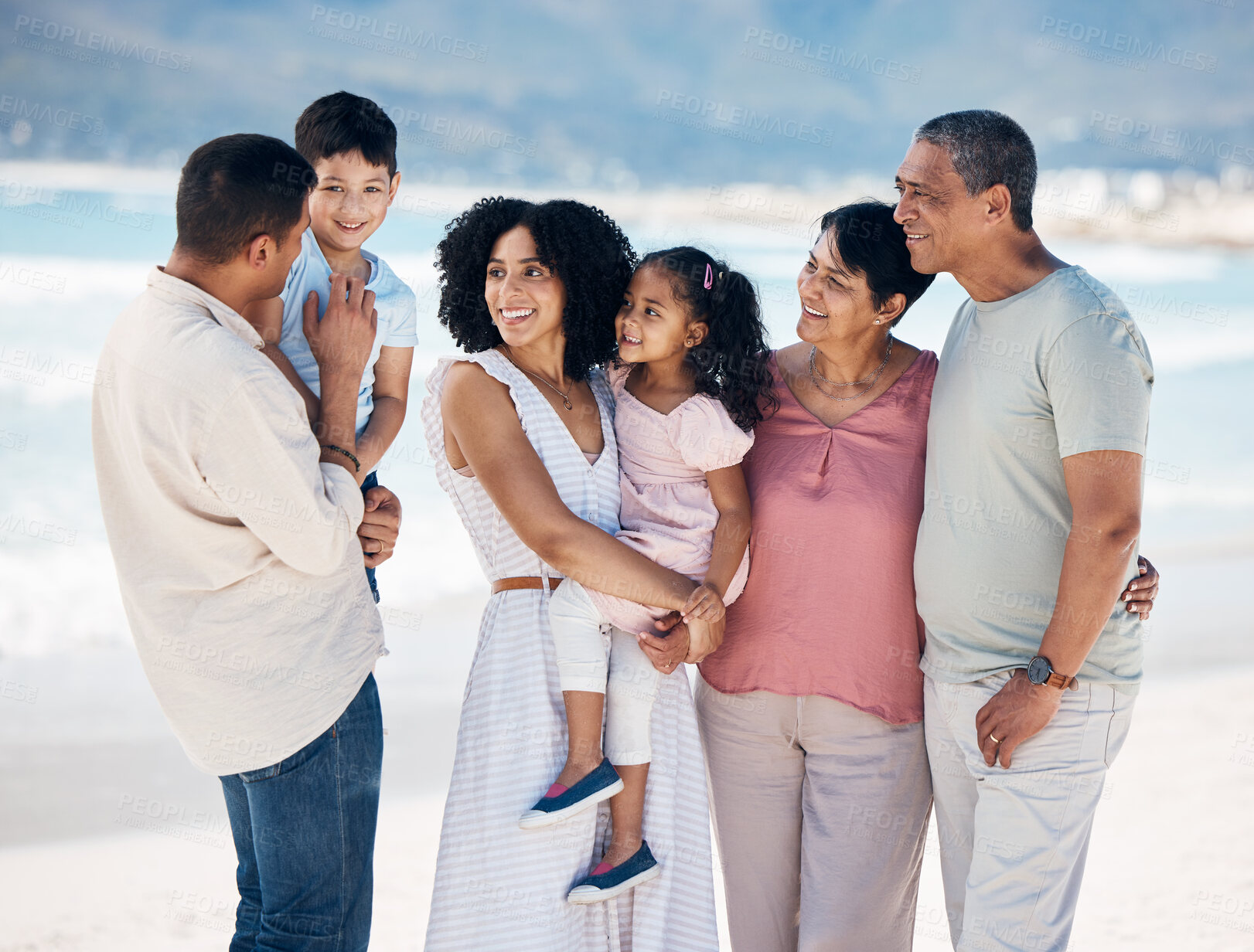 Buy stock photo Grandparents, kids and parents at beach, big family or talk with smile, care or bonding on vacation. Mother, father and senior people with children, chat or love in summer sunshine for holiday by sea