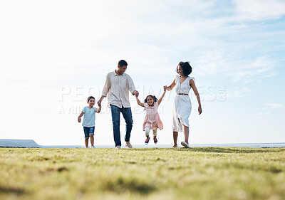 Buy stock photo Holding hands, family and outdoor at a park with love, care and happiness together in nature. Young man and woman or parents with children on walk, sky and playing on fun journey or travel holiday