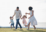 Happy family, holding hands and outdoor at a park with a love, care and happiness together in nature. Young man and woman or parents with children for walk, travel and playing on holiday or vacation