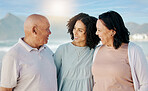 Happy, beach and woman with her senior parents on a family vacation, holiday or adventure. Love, smile and young female person talking to her elderly mother and father by the ocean on a weekend trip.