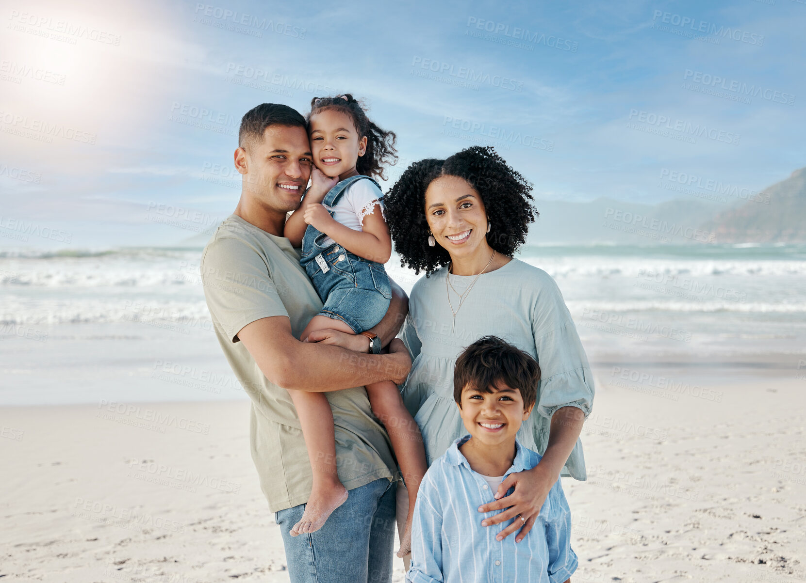 Buy stock photo Mom, dad and children in portrait, ocean and happy with hug, love and bonding on vacation in summer sunshine. Parents, kids and smile together at beach, holiday and outdoor by sea, waves and sand