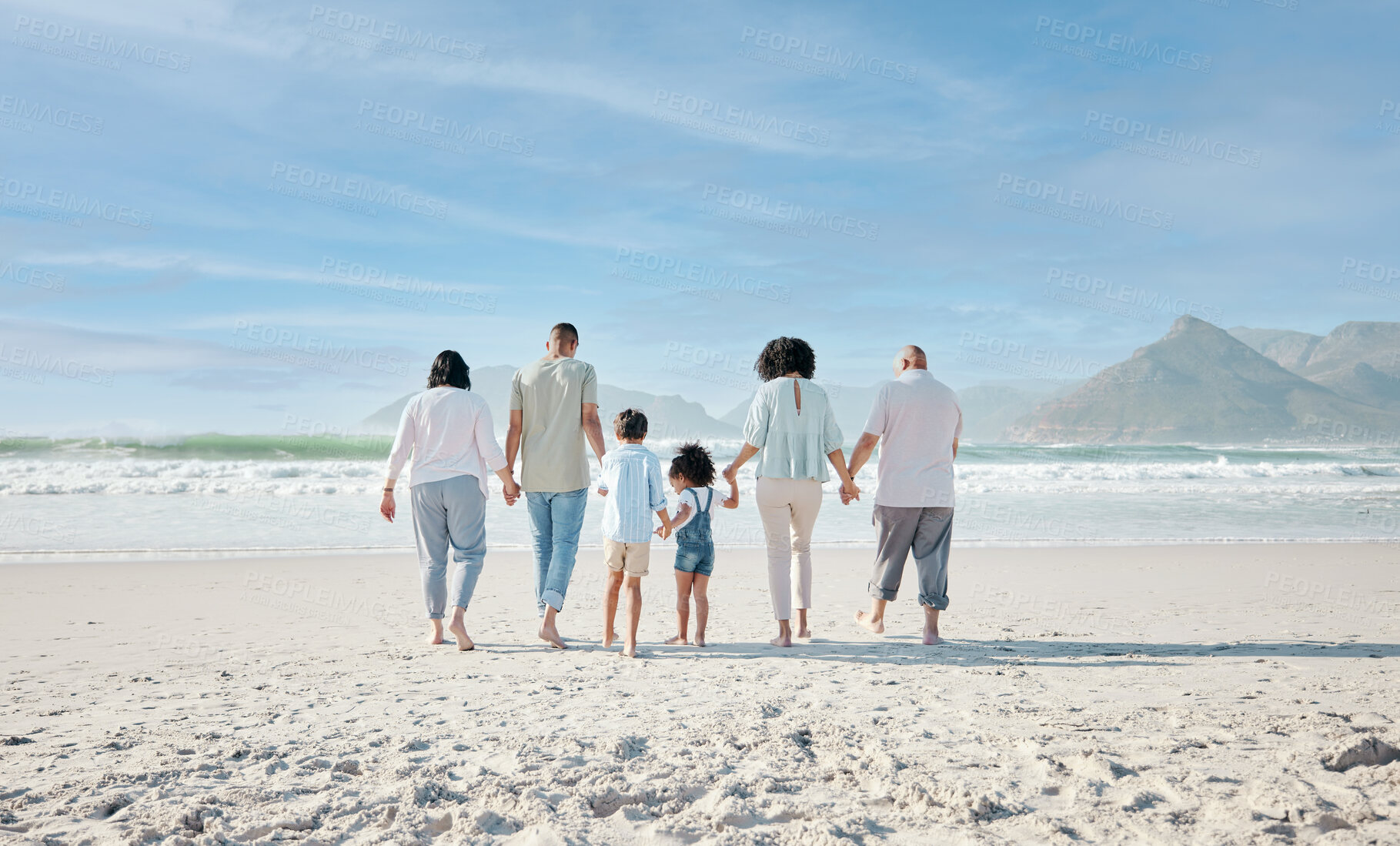 Buy stock photo Family, holding hands and walking outdoor on a beach with love, care and happiness on summer vacation. Behind, space in sky or travel with men, women and children together for holiday adventure