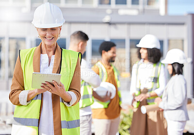 Buy stock photo Tablet, architecture and a senior woman construction worker on a building site with her team in the city. Technology, planning and safety with a female engineer reading a blueprint on the internet
