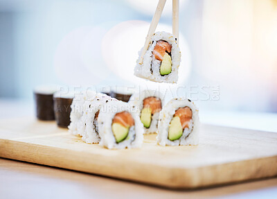 Buy stock photo Sushi, food on wood board with fish and eating, salmon and rice with avocado, healthy and luxury. Japanese cuisine, catering with lunch or dinner meal, chopsticks and seafood, nutrition and gourmet