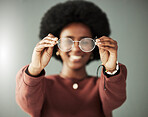 Hands, woman and closeup of glasses for vision, eyesight and prescription eye care in studio. Person with optical frame, lens choice and eyewear fashion for test, healthcare assessment and optometry 