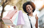 Woman, shopping bag and thumbs up in city for success, thank you and support, like or yes emoji. Happy portrait of african person, winner or customer gift, competition or giveaway and ok hand or sign