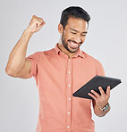 Happy asian man, tablet and fist pump in winning, celebration or promotion against a white studio background. Excited male person with technology app in happiness for victory, success or good news